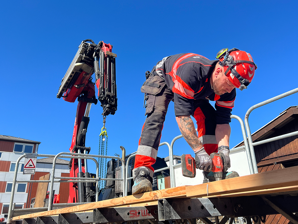 Fitter and driver Kenneth Kusiak is taking the floorboards off a work platform as part of a dismantling.