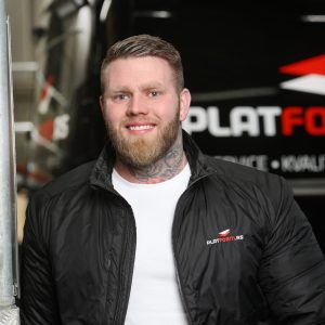 Morten G Hansen står foran en bil og smiler