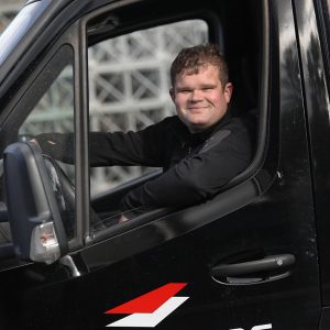 Rasmus Jensen sidder i sin bil og smiler